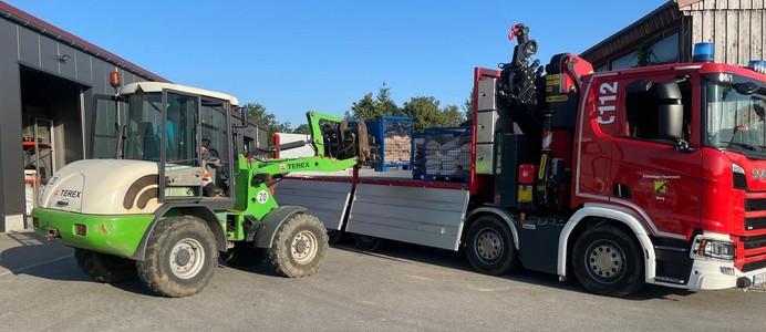 Beladen des Wechselladers mit den mit Sandsäcken gefüllten Gitterboxen Beladen des Wechselladers mit den mit Sandsäcken gefüllten Gitterboxen